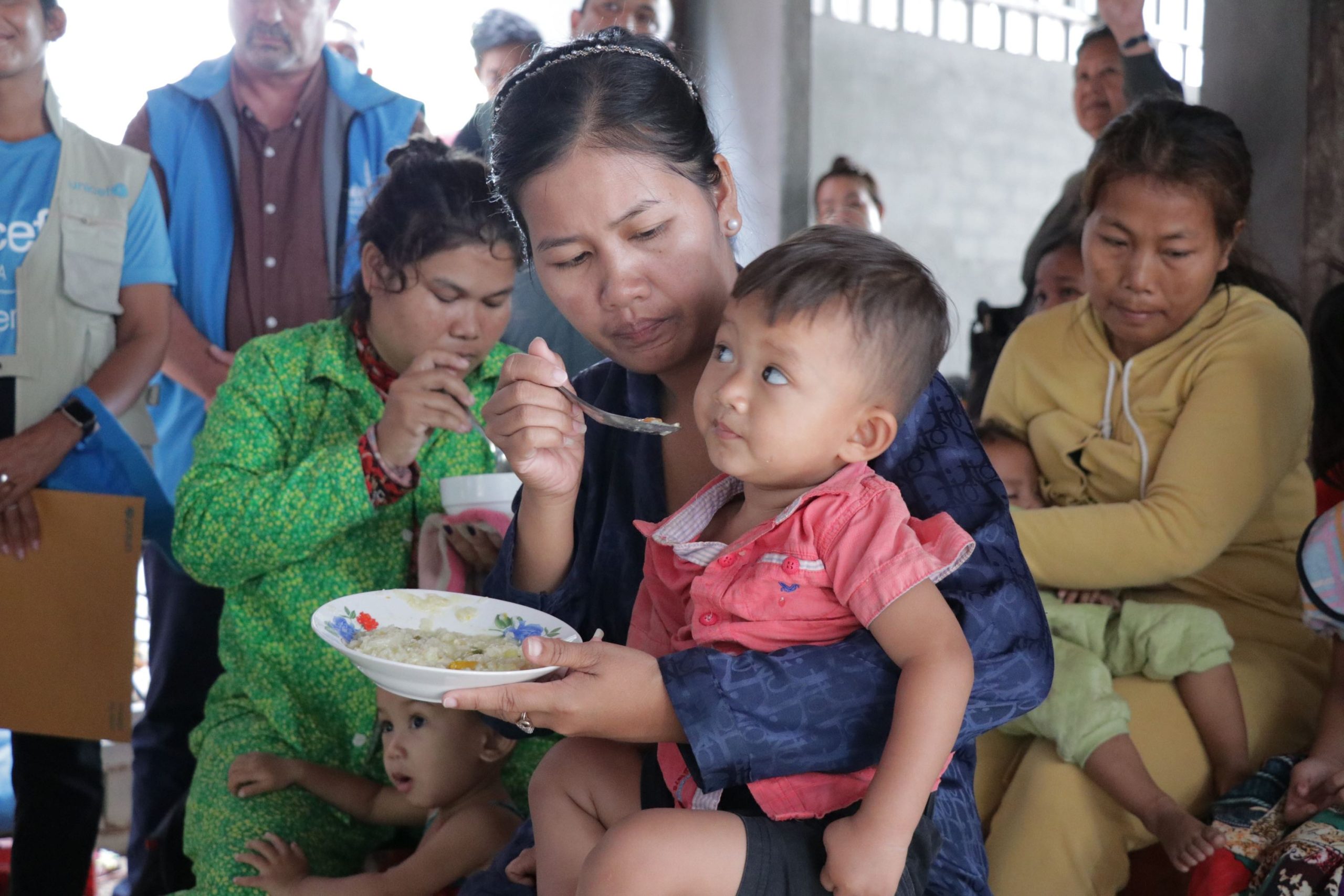 A mother is seen feeding her child during a malnutrition community information session in Kratie Province, Cambodia. Credit: UNICEF/UN0803508/Moeun