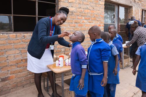 Children receive medicine during a Mass Drug Administration (MDA) campaign. Credit: Sightsavers